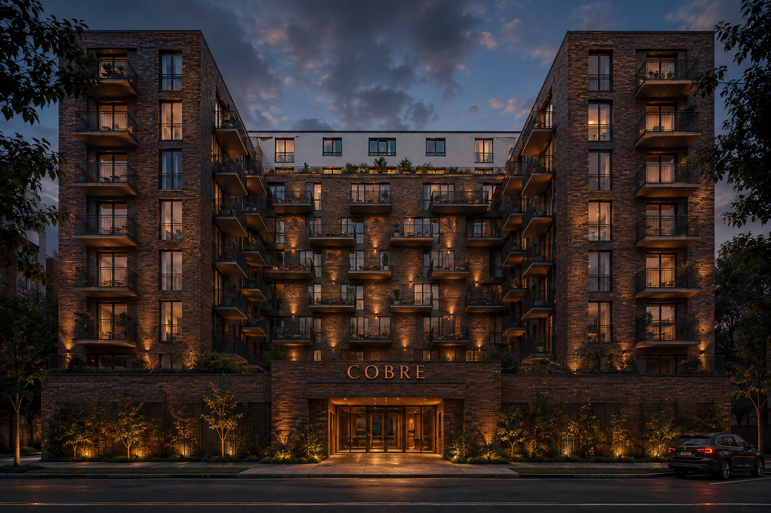 Fachada del edificio Residencial Cobre al atardecer, con el letrero COBRE sobre la entrada